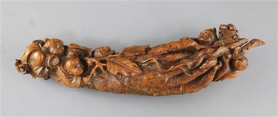 A Chinese boxwood carving of figures clambering over a giant finger citron, length 30cm